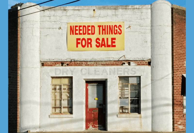 The storefront of an old dry cleaner's business with a faded sign. Original public domain image from Wikimedia Commons